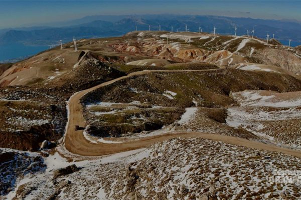 Paysage lunaire avec champ d'éolienne et vue sur Patras