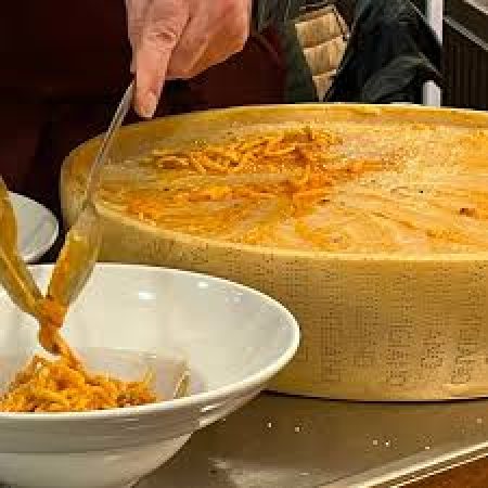 Préparation des pâtes dans la meule du parmigiano lors de notre passage au restaurant en Italie